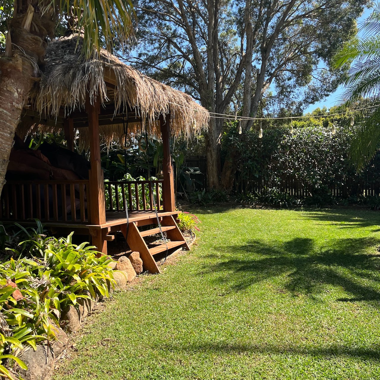 Backyard cabana and lawn under established trees